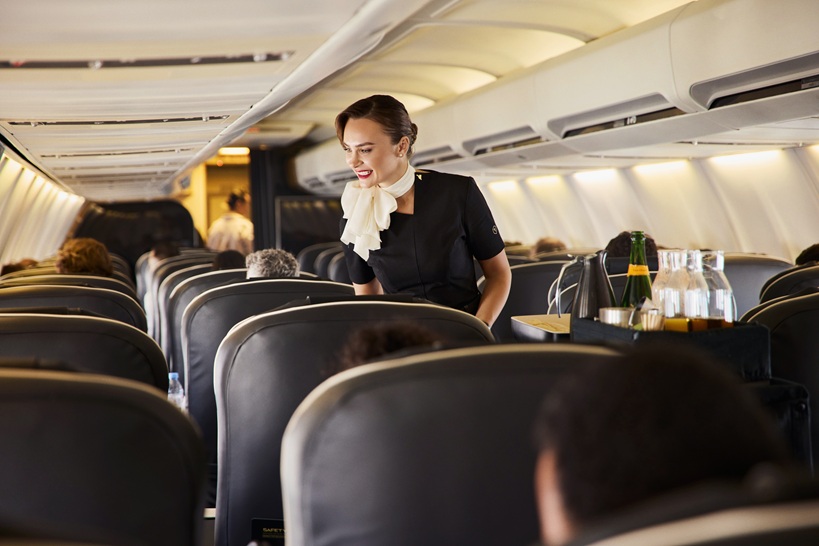 Flugbegleiterin im Flugzeug, kümmert sich um die Passagiere Flugbegleiterin im Flugzeug, kümmert sich um die Passagiere