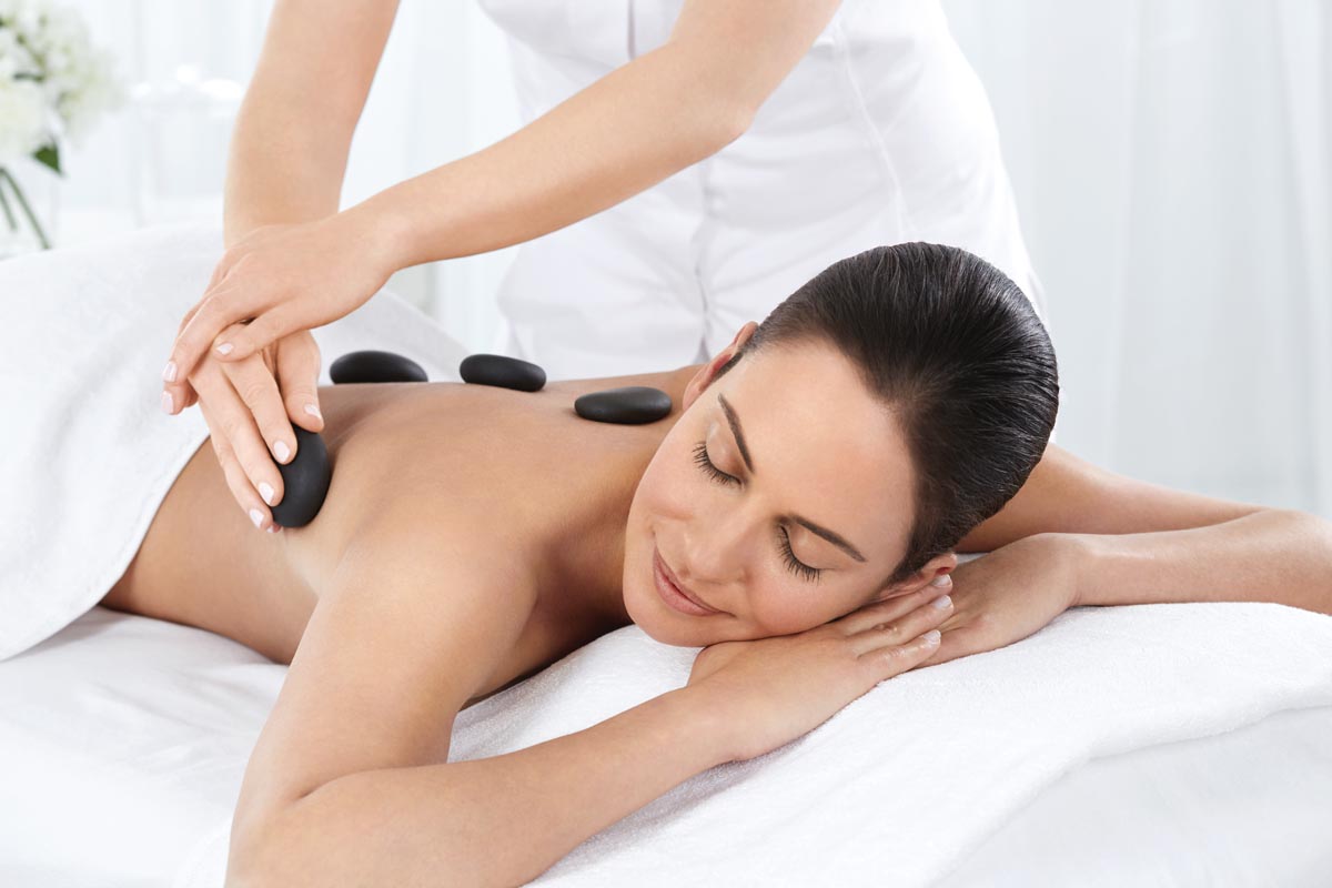 Frau genießt Hot-Stone-Massage im Neptune Spa auf Kos – Entspannung und Luxus vereint.