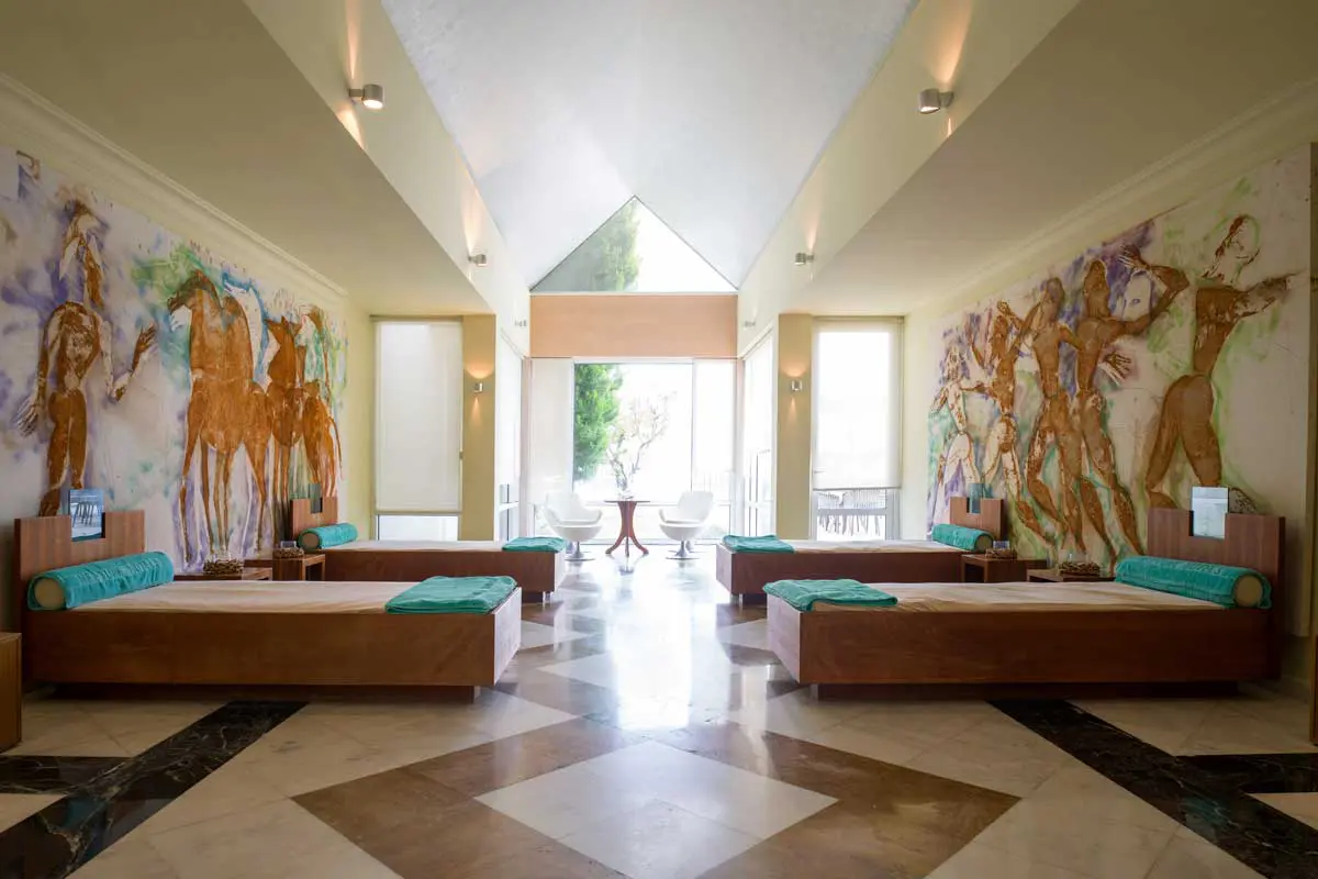 Moderner Ruhebereich im Neptune Spa mit Tagesbetten und antiker Wandkunst auf Kos.
